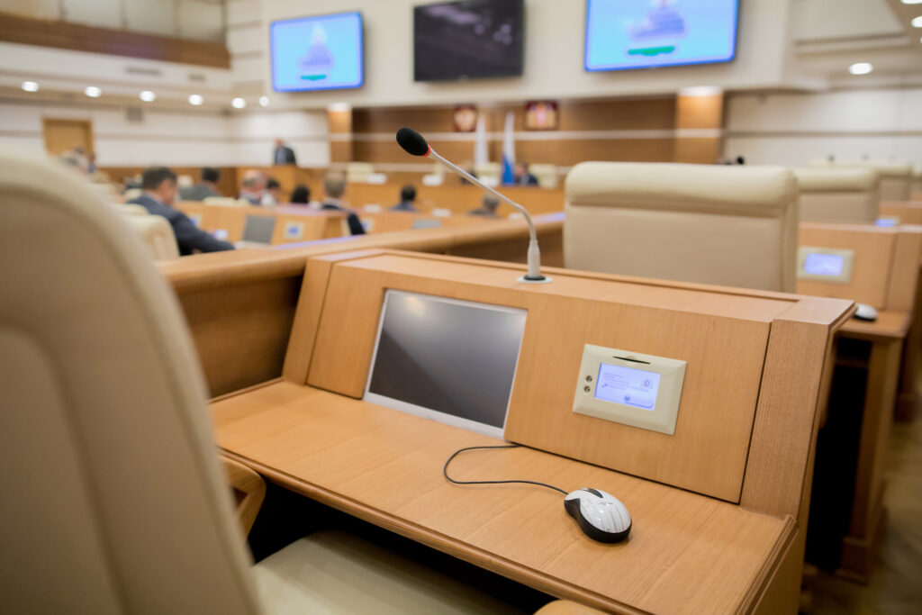 A screen at a desk in a local government auditorium to record public meeting minutes
