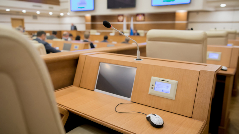 A screen at a desk in a local government auditorium to record public meeting minutes